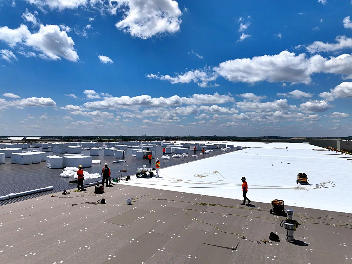 Crew installing a white TPO roof on a large warehouse – TPO roofs project gallery