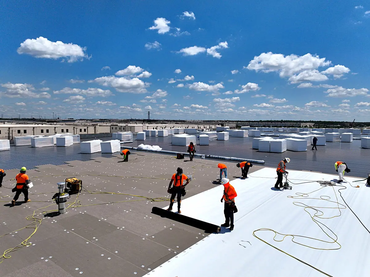 Crew installing a white TPO roof on a large warehouse – TPO roofs project gallery