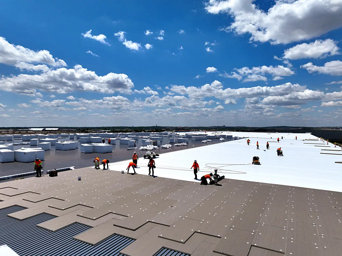 Crew installing a white TPO roof on a large warehouse – TPO roofs project gallery