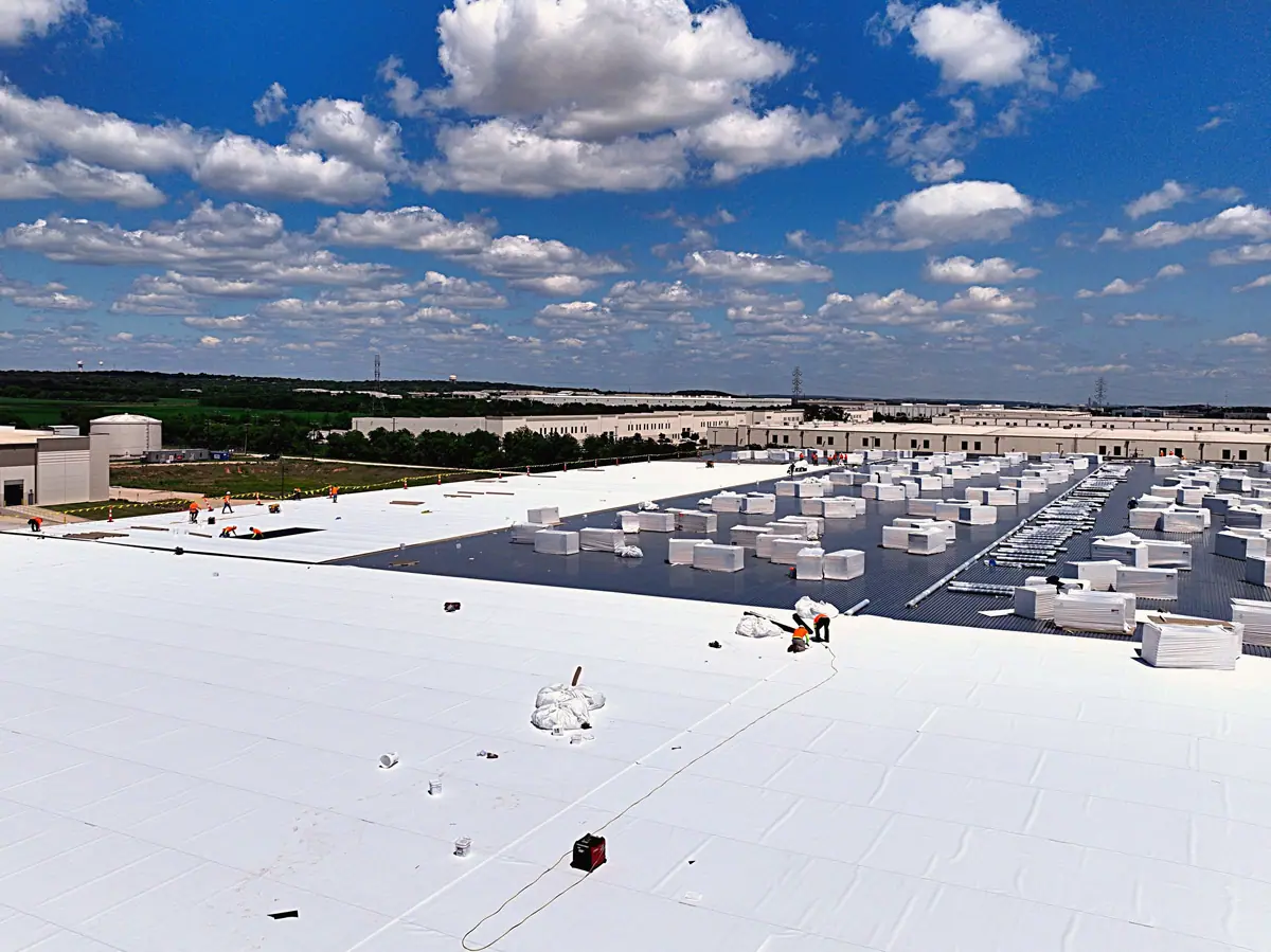 Crew installing a white TPO roof on a large warehouse – TPO roofs project gallery