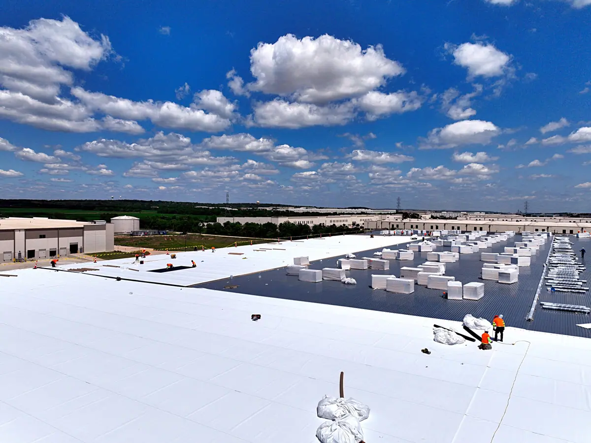 Crew installing a white TPO roof on a large warehouse – TPO roofs project gallery