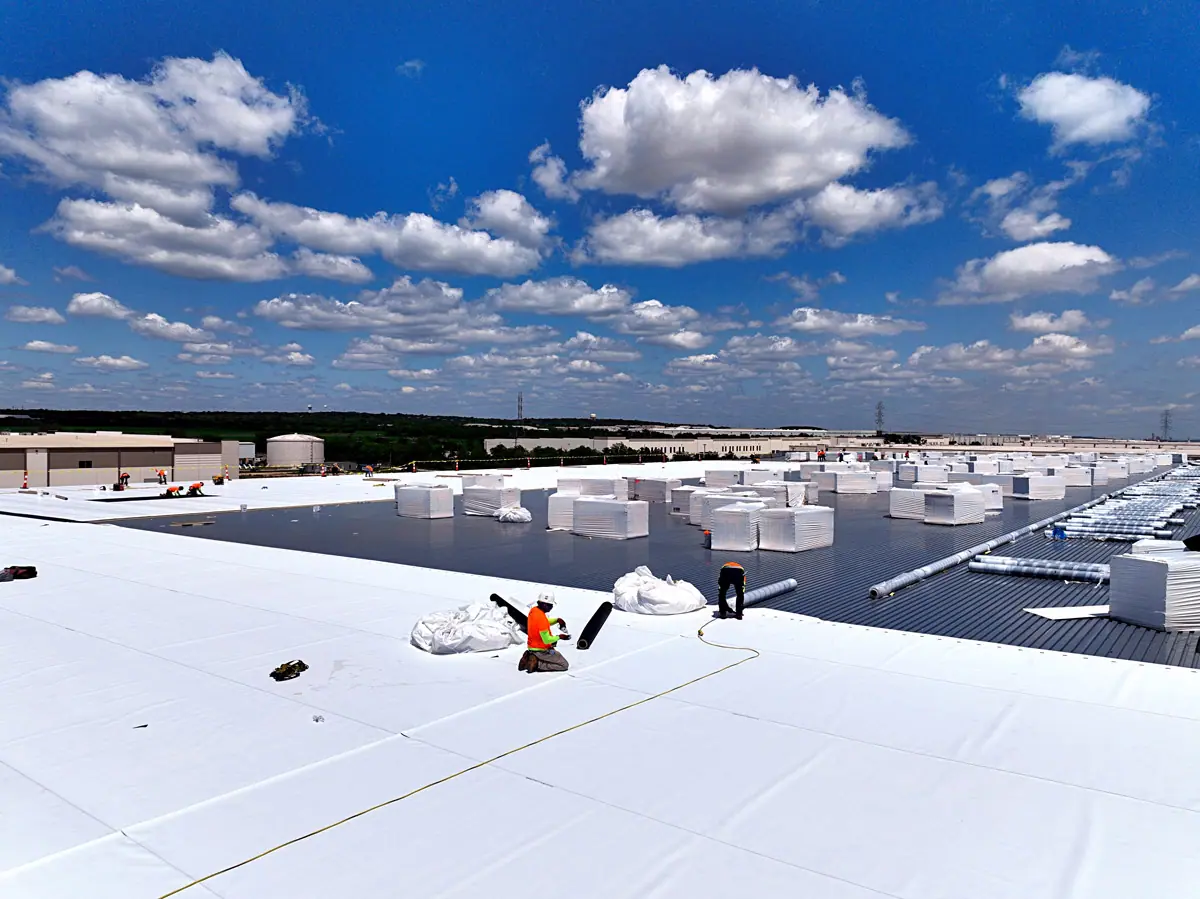Crew installing a white TPO roof on a large warehouse – TPO roofs project gallery