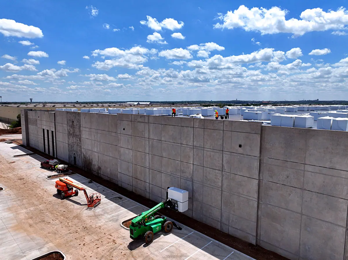 Lift raising roofing materials up a warehouse's concrete wall – TPO roofs project gallery
