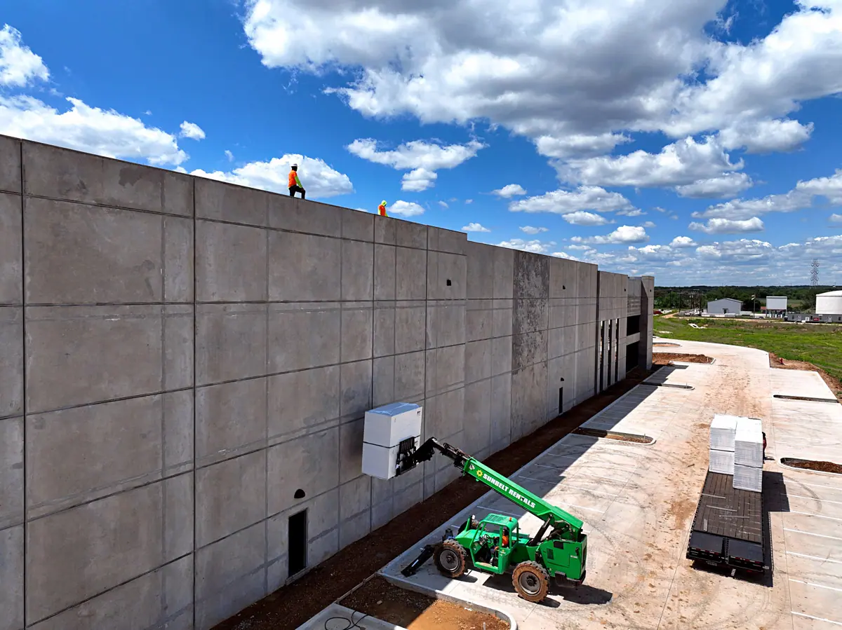 Lift raising roofing materials up a warehouse's concrete wall – TPO roofs project gallery