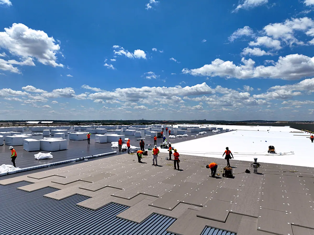 Crew installing a white TPO roof on a large warehouse – TPO roofs project gallery
