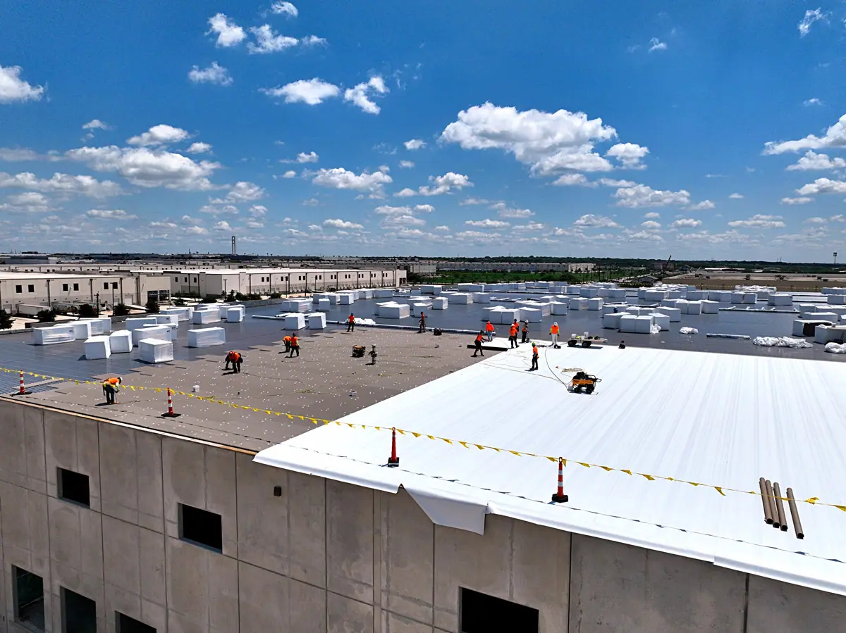 Crew installing a white TPO roof on a large warehouse – TPO roofs project gallery