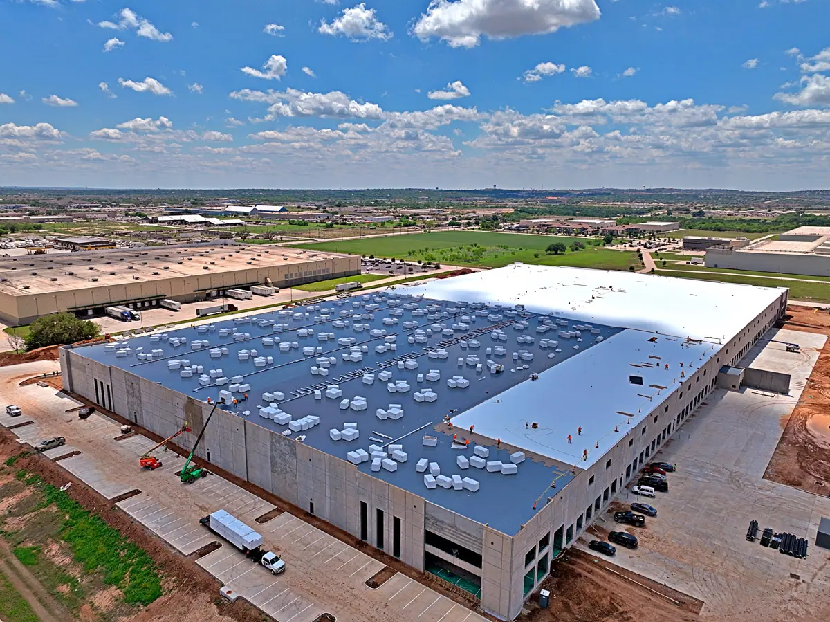 Aerial view of a large warehouse during a TPO roof installation