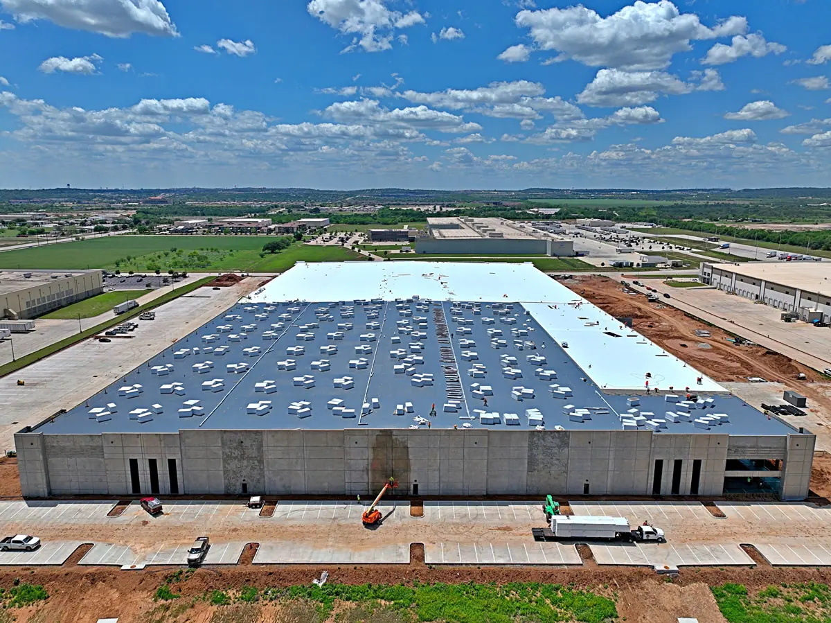 Aerial view of a large warehouse during its TPO roof installation – TPO roofs project gallery