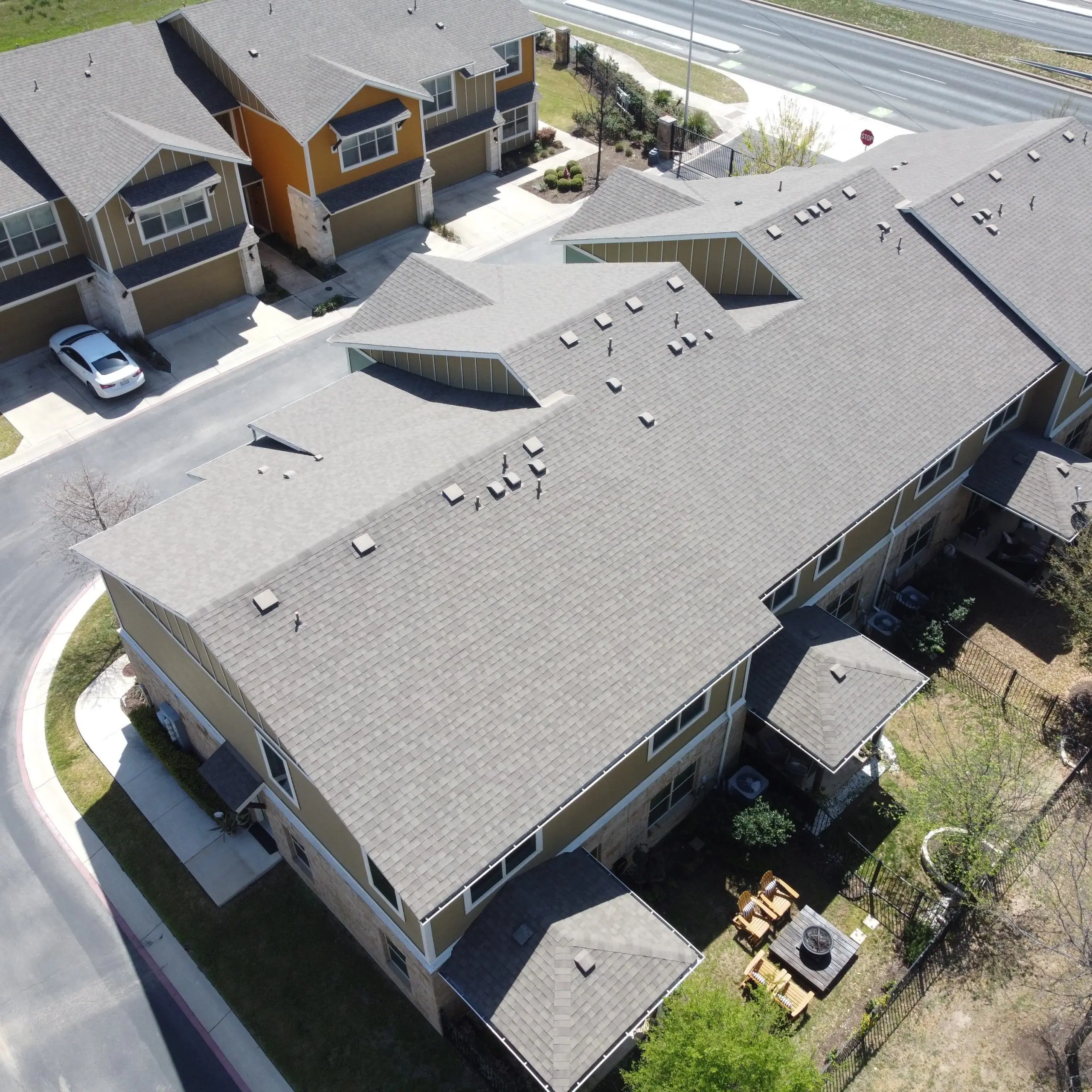 Aerial view of a townhome complex with gray shingle roofs – Waco roofing company