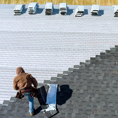 Roofers installing shingles on a large roof – roof types in Austin