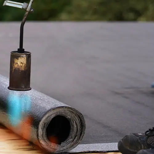 Roofer torching down a modified bitumen roll – Waco roofing company