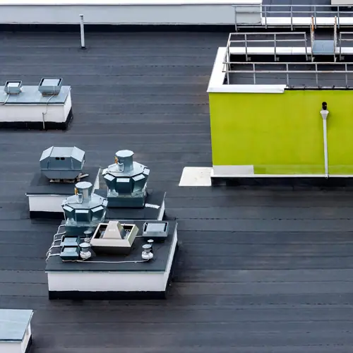 Dark flat commercial roof with rooftop equipment – roof types in Austin