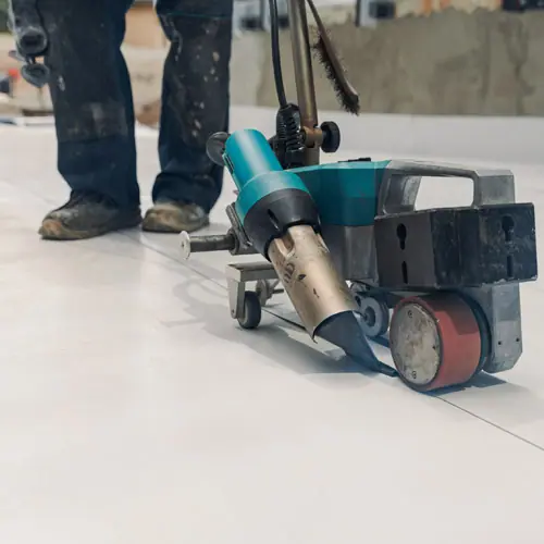 Hot-air welder seaming a white TPO roof membrane – Waco roofing company